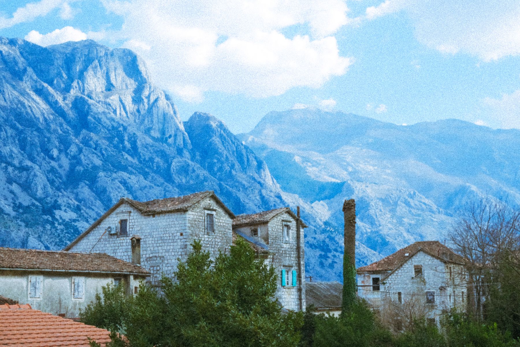 Pueblo de montaña con casas de piedra frente a los Alpes